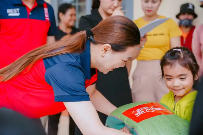 Chị Nguyễn Thị Thuỳ Dung - chủ Bưu cục An Lạc, Thị xã Buôn Hồ, Đăk Lăk trao gạo cho trẻ em Ê-đê. Ảnh: BEST Express